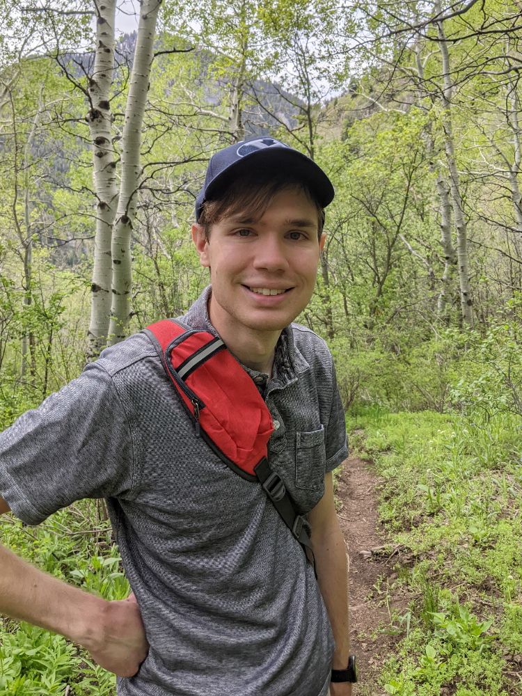 Image of Dallin hiking through aspen trees
