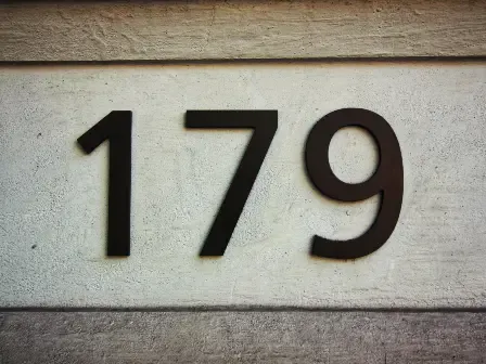 Close-up of house numbers on a wall representing address lookup and address verification