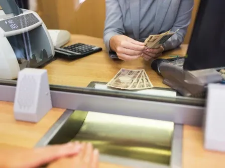 Bank teller counting cash.