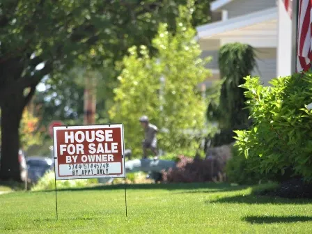 For sale by owner sign outside of a house.