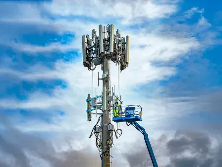 Technicians servicing a cellular tower for accurate latitude and longitude of an address for telecom network mapping. 