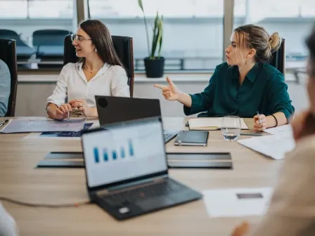 Women in a meeting with data on their computers