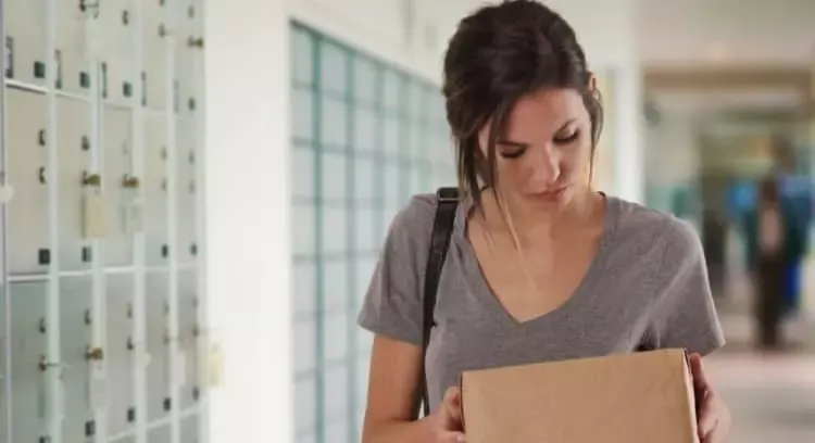 Woman holding a package at a mailbox facility - PO Box-Only ZIP Codes