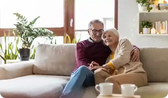 A senior couple contentedly sitting on a couch together