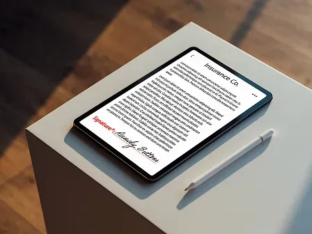A digital tablet displaying an insurance document with an electronic signature rests on a modern white pedestal beside a stylus, representing paperless workflows and digital insurance processing.
